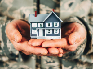 Military member holding miniature house